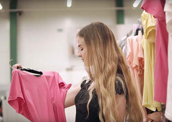 Young woman looking at clothes in store