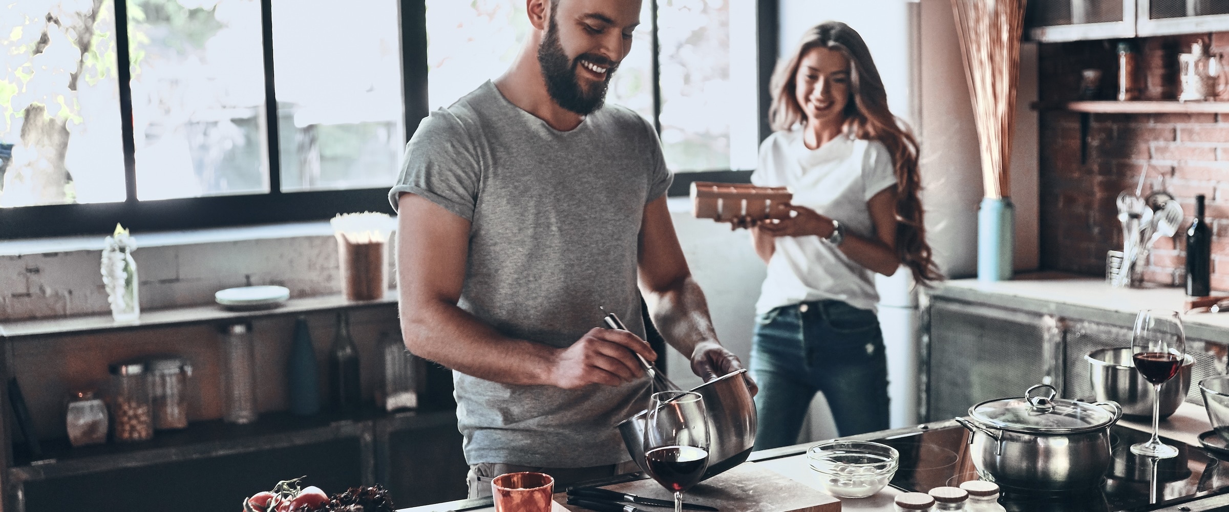 Photo of a young couple making a meal together at home.