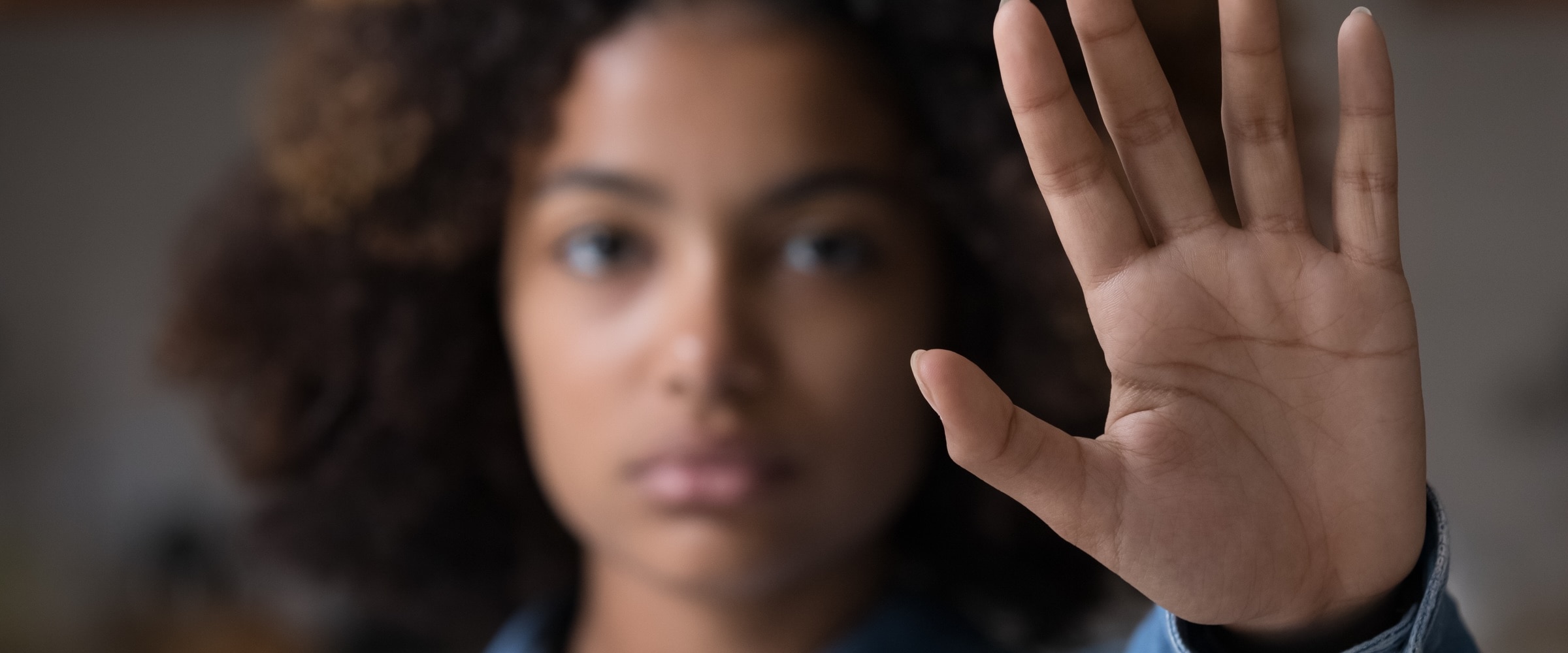 Woman with hand in the air as to communicate to stop.