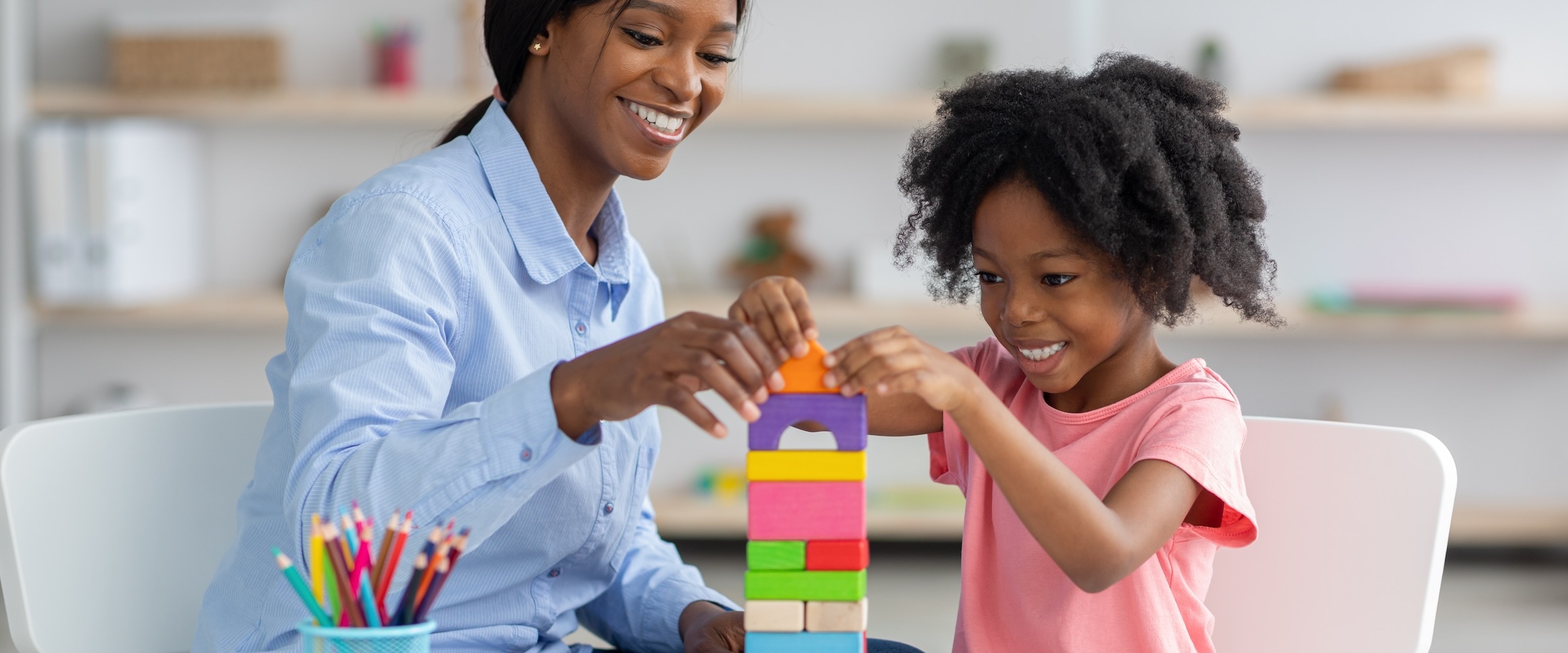 Photo of mom and daughter playing with blocks.