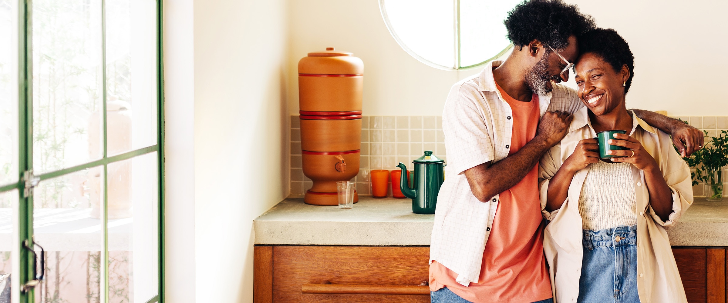 Photo of African-american couple standing close together and sharing a coffee.