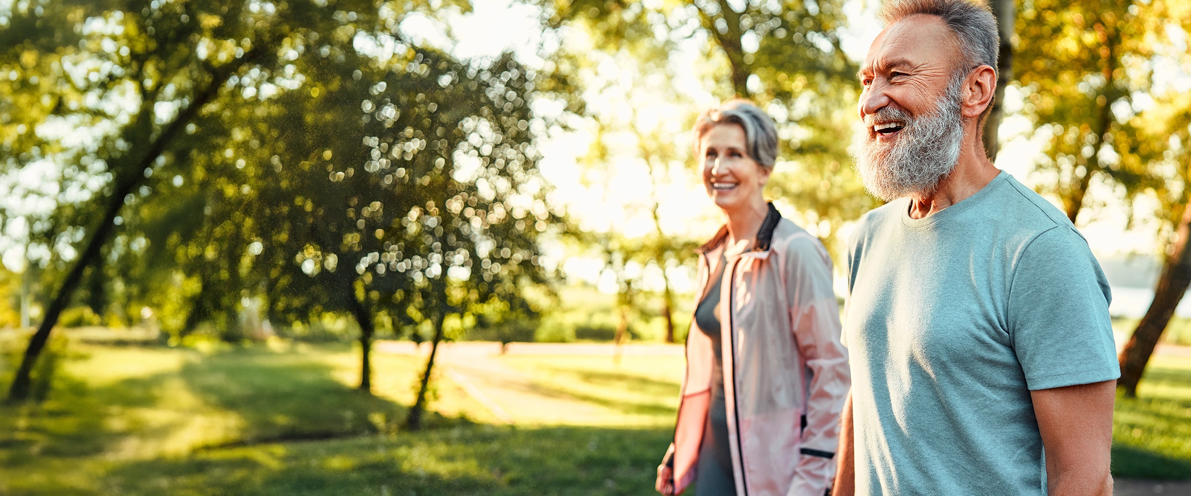 Photo of older couple walking in a park.
