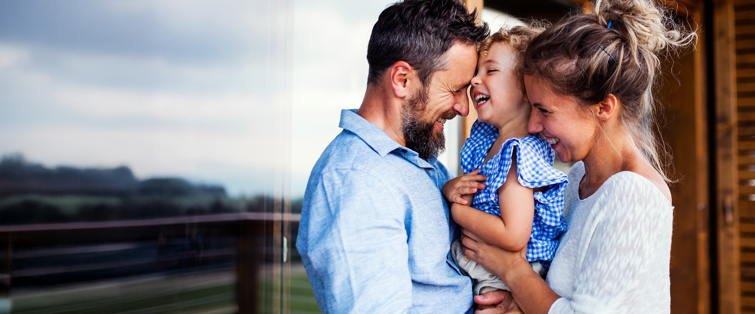 Photo of father, child and wife snuggled closely together.