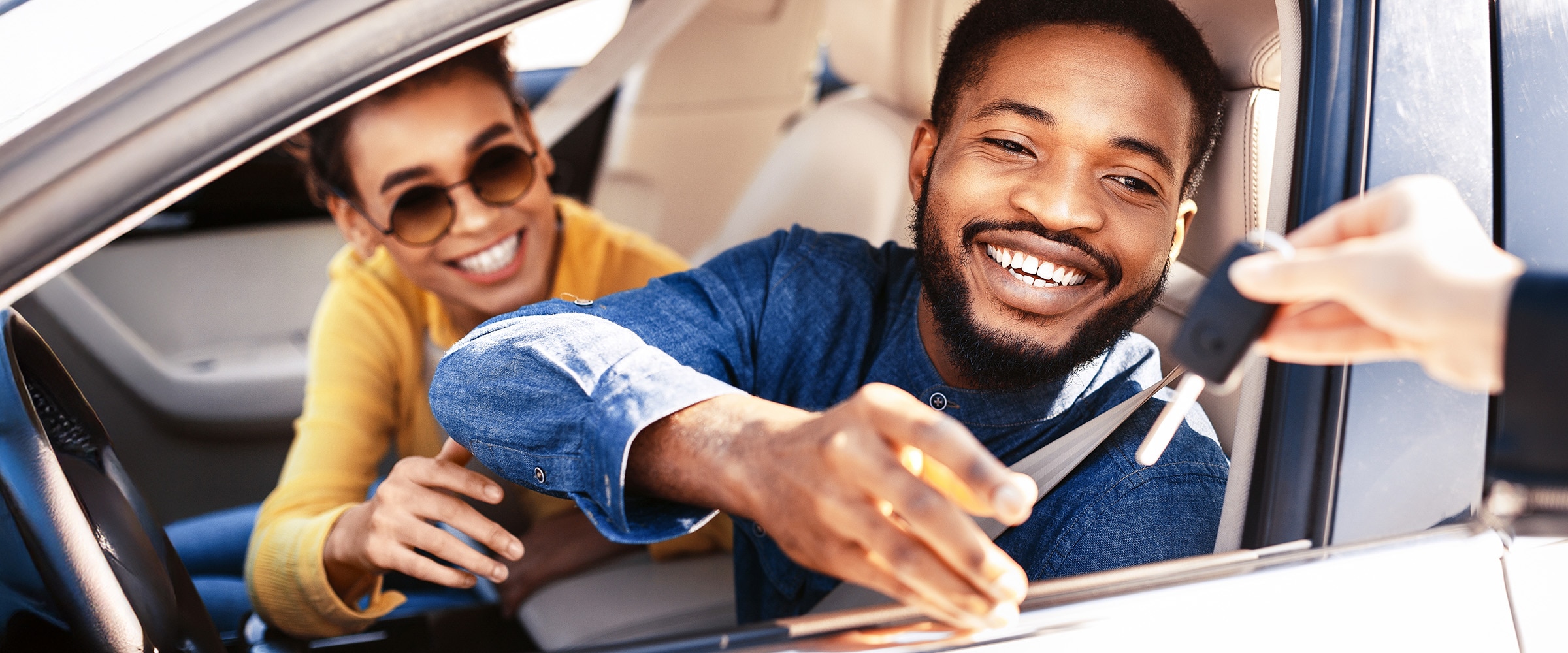 Photo of man in new car being handed the keys.