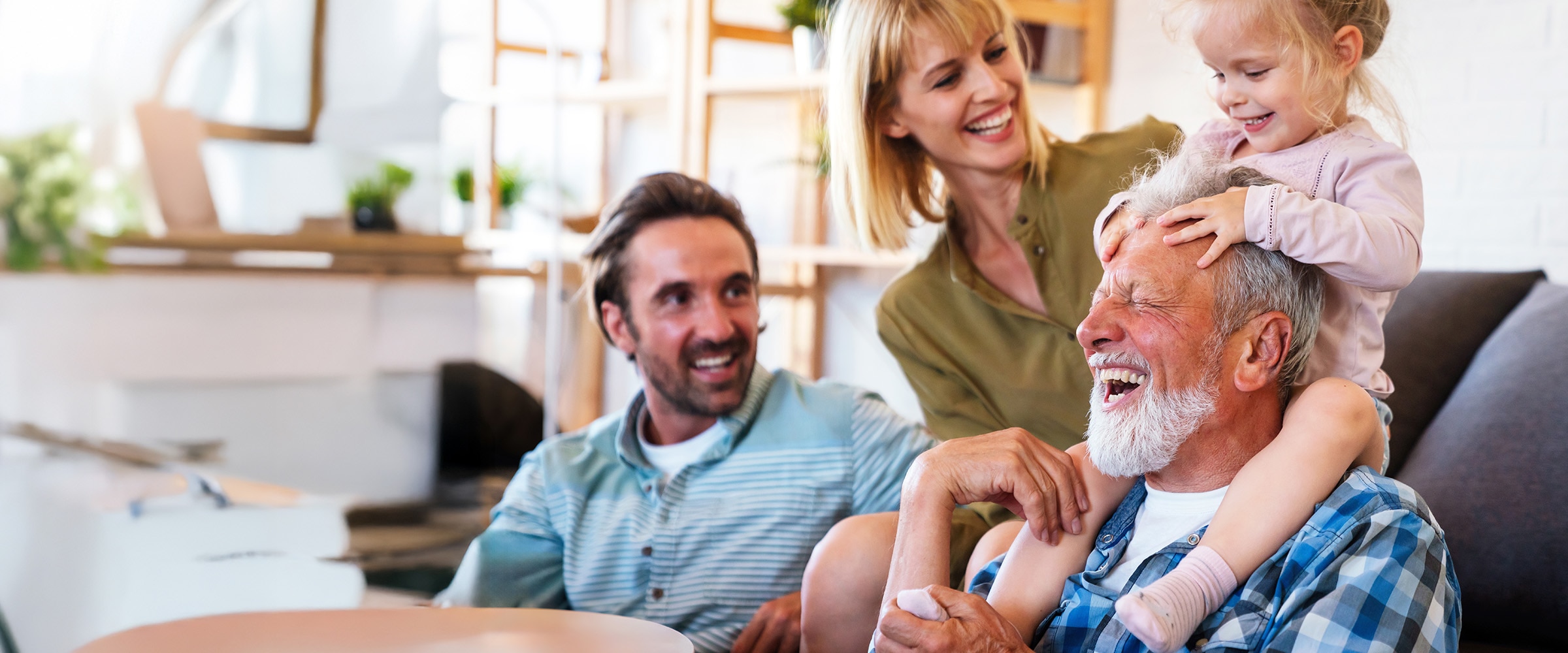 Photo of a family featuring a grandfather together on a couch.