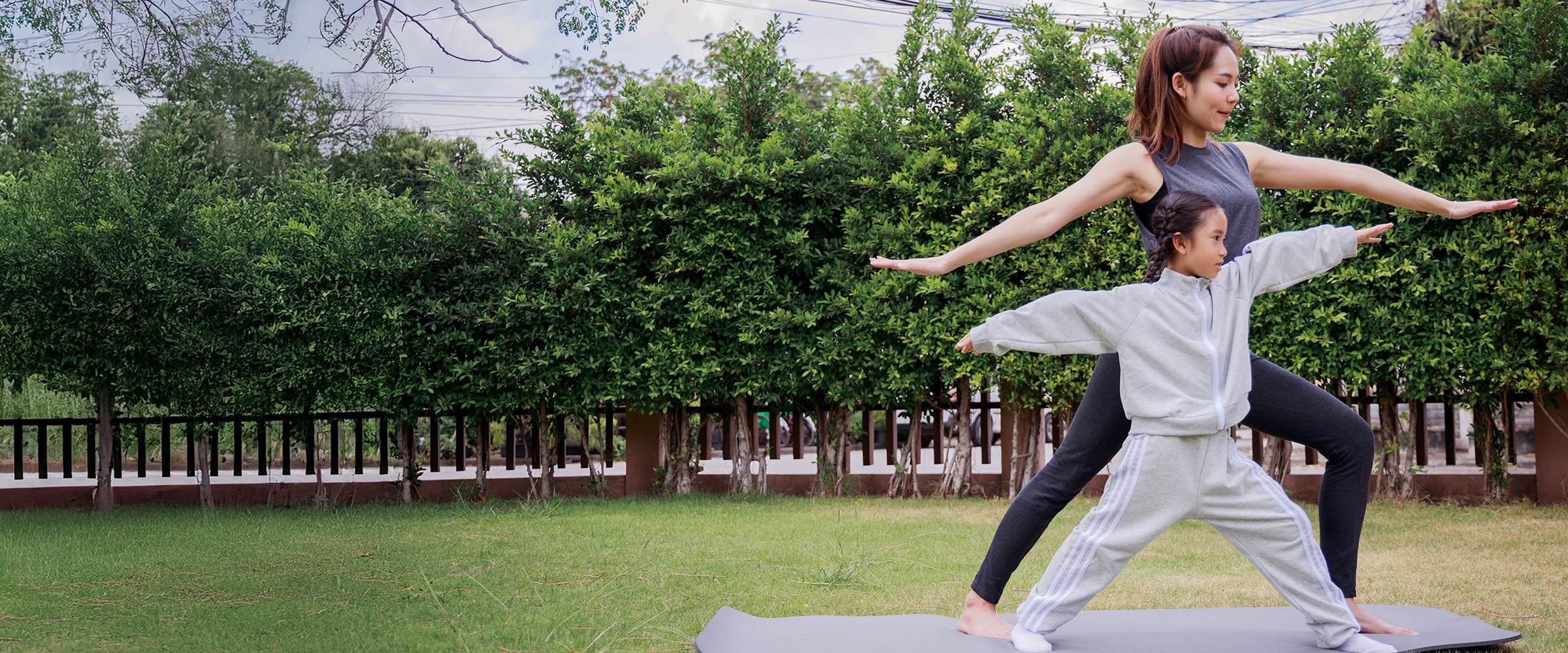Photo of adult and teen females doing stretching exercises outdoors.