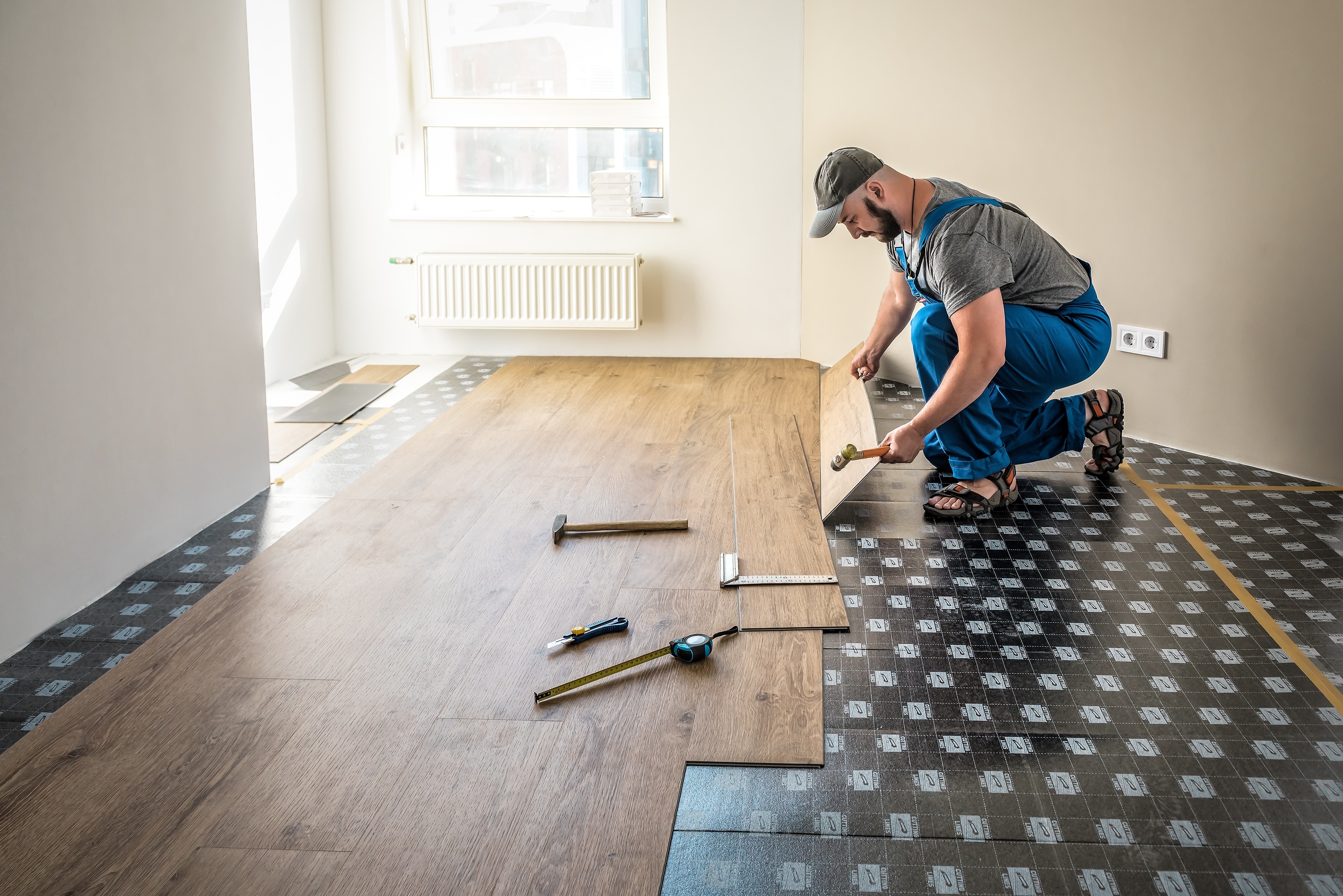 Worker installing vinyl flooring