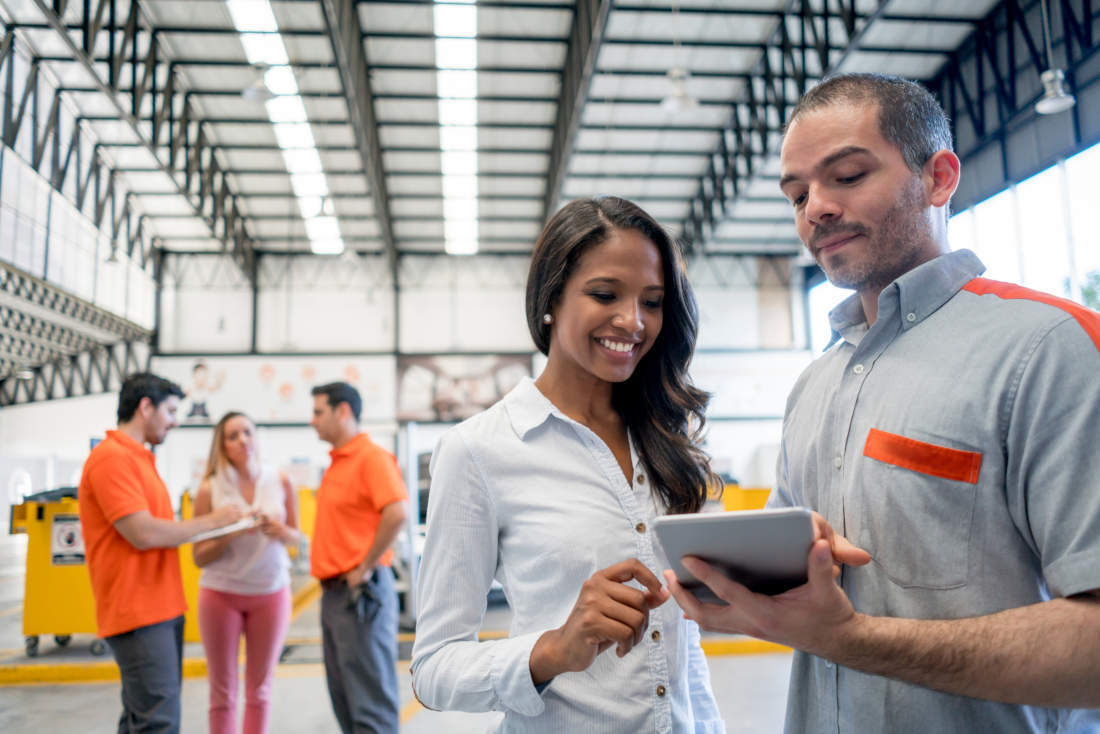 Auto service professional reviewing Car Care financing transaction with woman.